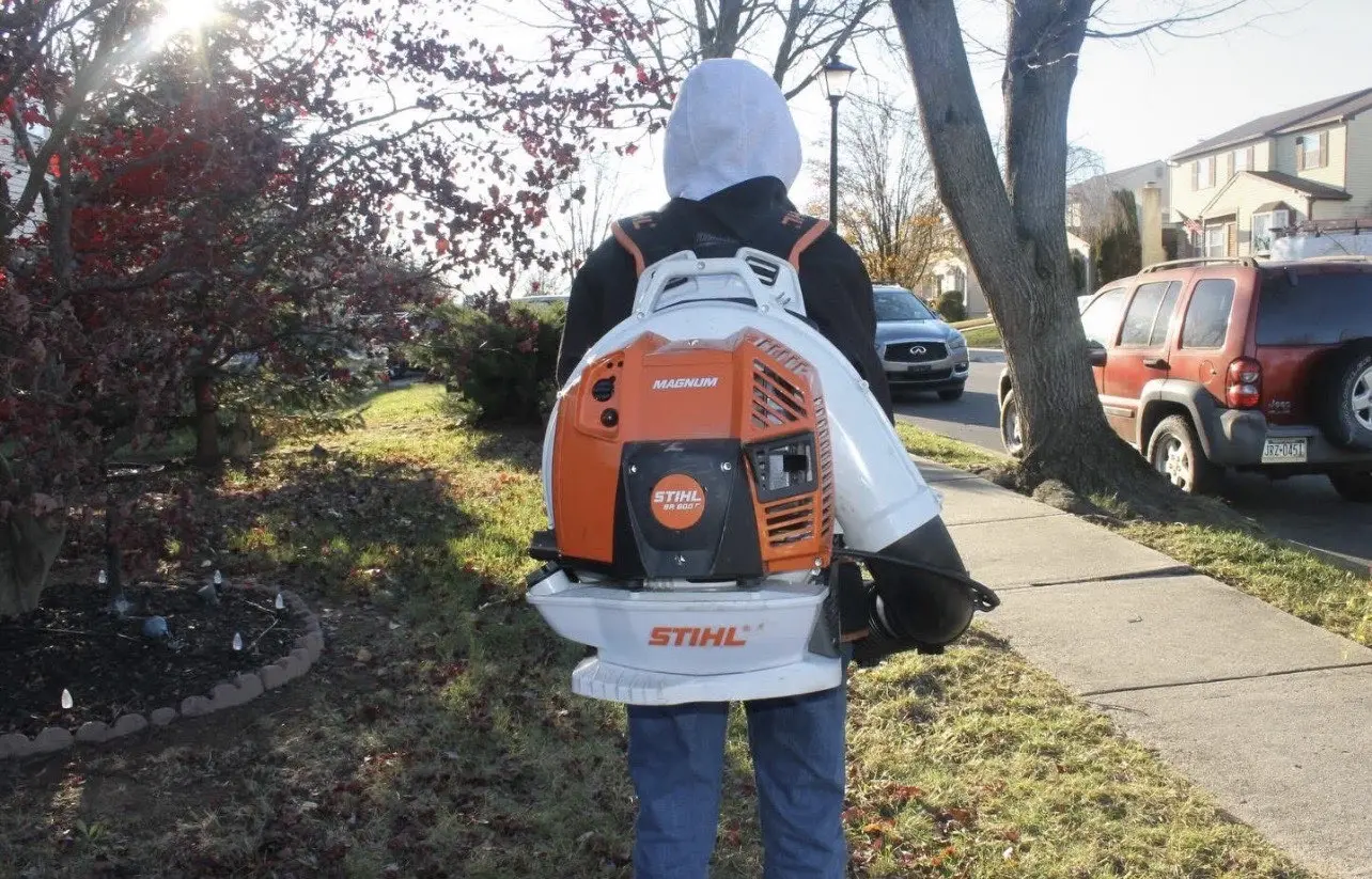 T and J Landscaping team member using a backpack blower